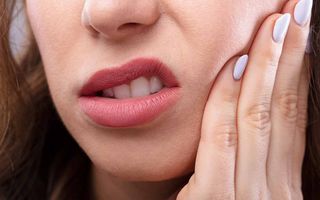 Close up of a woman face holding side of face